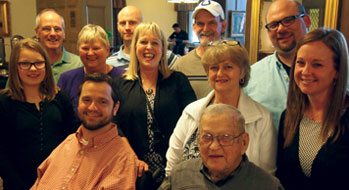 Myron Rukes sits, surrounded by his family.